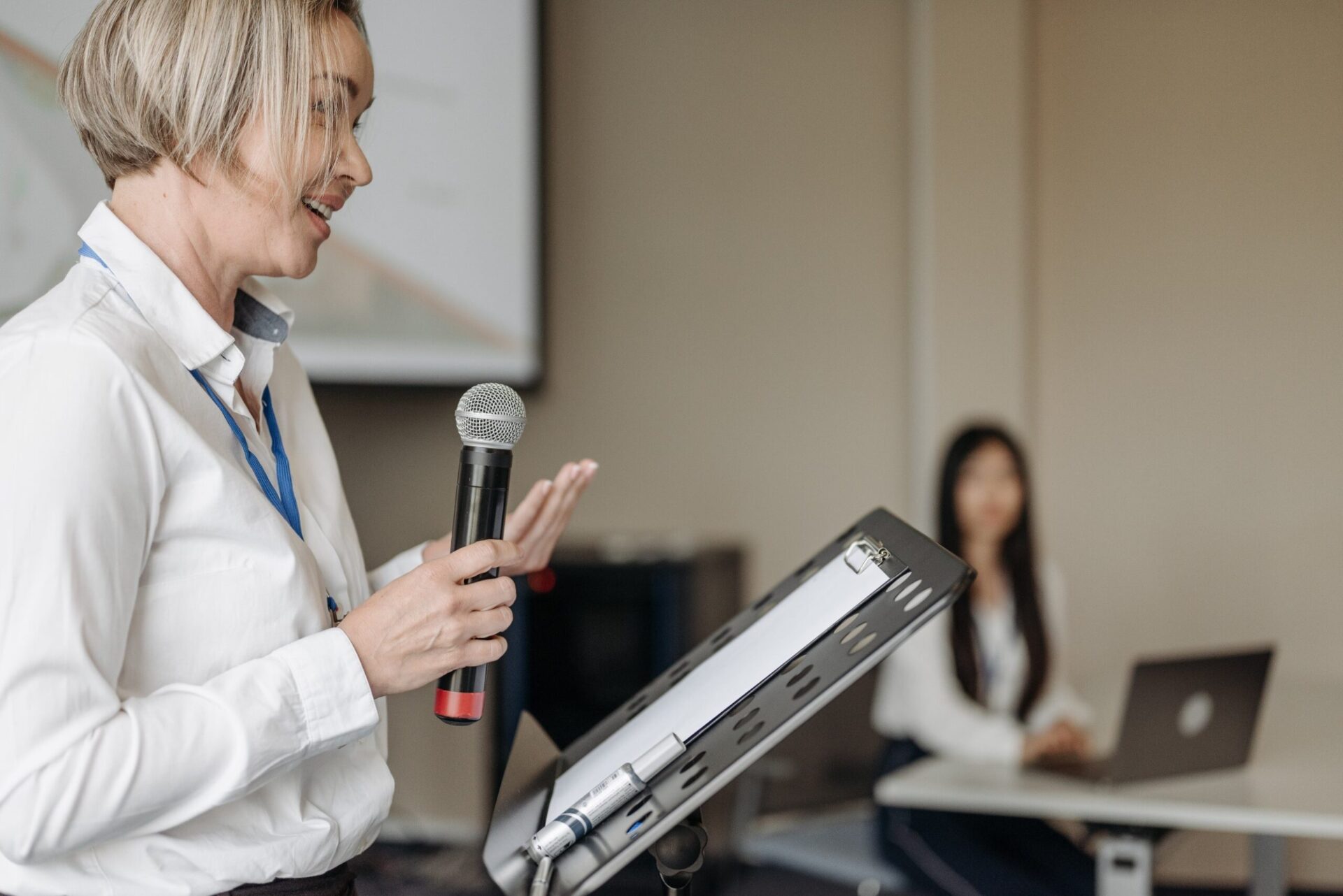 Une formatrice s'exprimant avec un micro pendant une session.