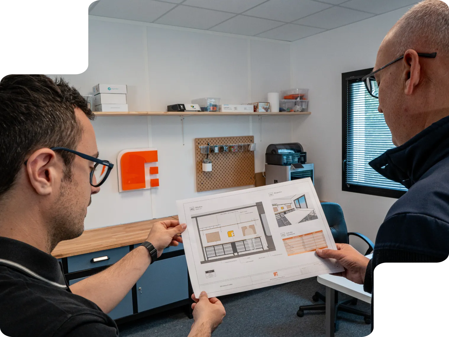 Analyse collaborative de projets techniques Deux hommes analysant une vue technique sur un plan détaillé dans un bureau moderne.