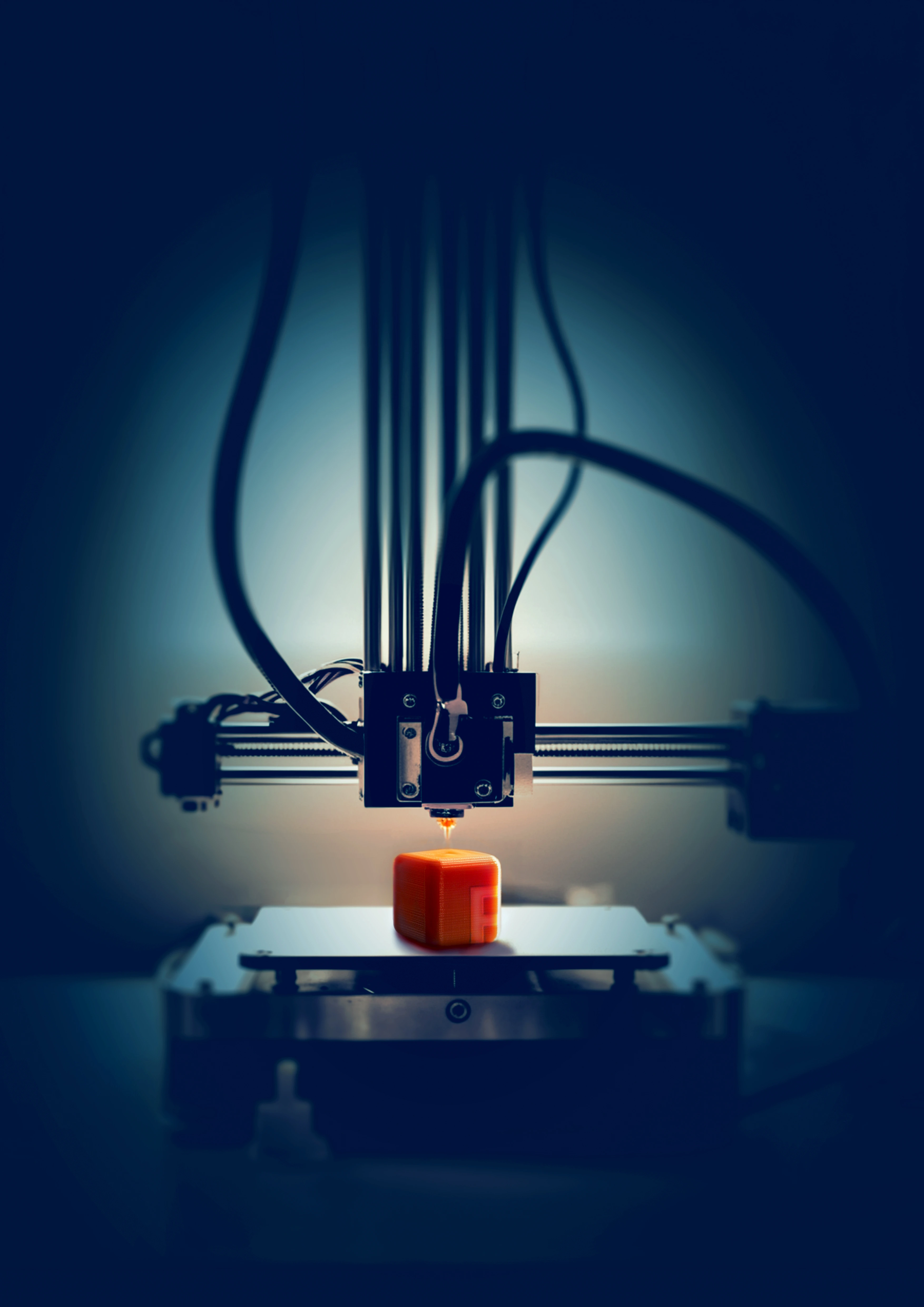 Maîtrisez l'impression 3D avec nos formations spécialisées Imprimante 3D créant un cube rouge sur une table de fabrication
