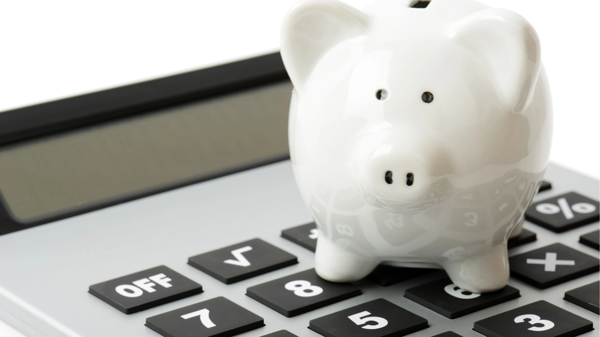 Tirelire blanche posée sur une calculatrice symbolisant le financement de la formation