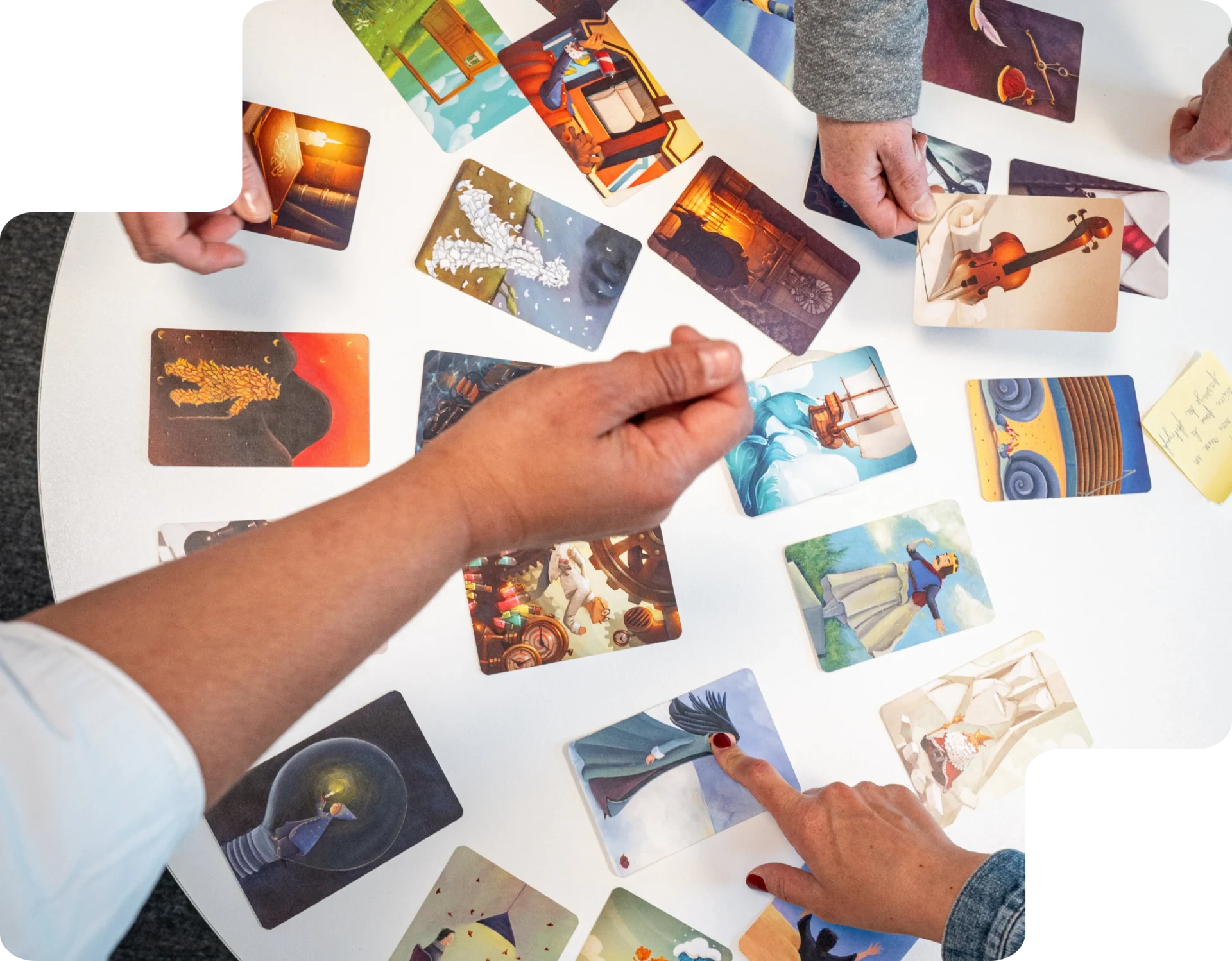 Libérer la parole et stimuler la réflexion grâce au jeu Mains de participants triant des cartes illustrées autour d’une table lors d’un atelier pédagogique.