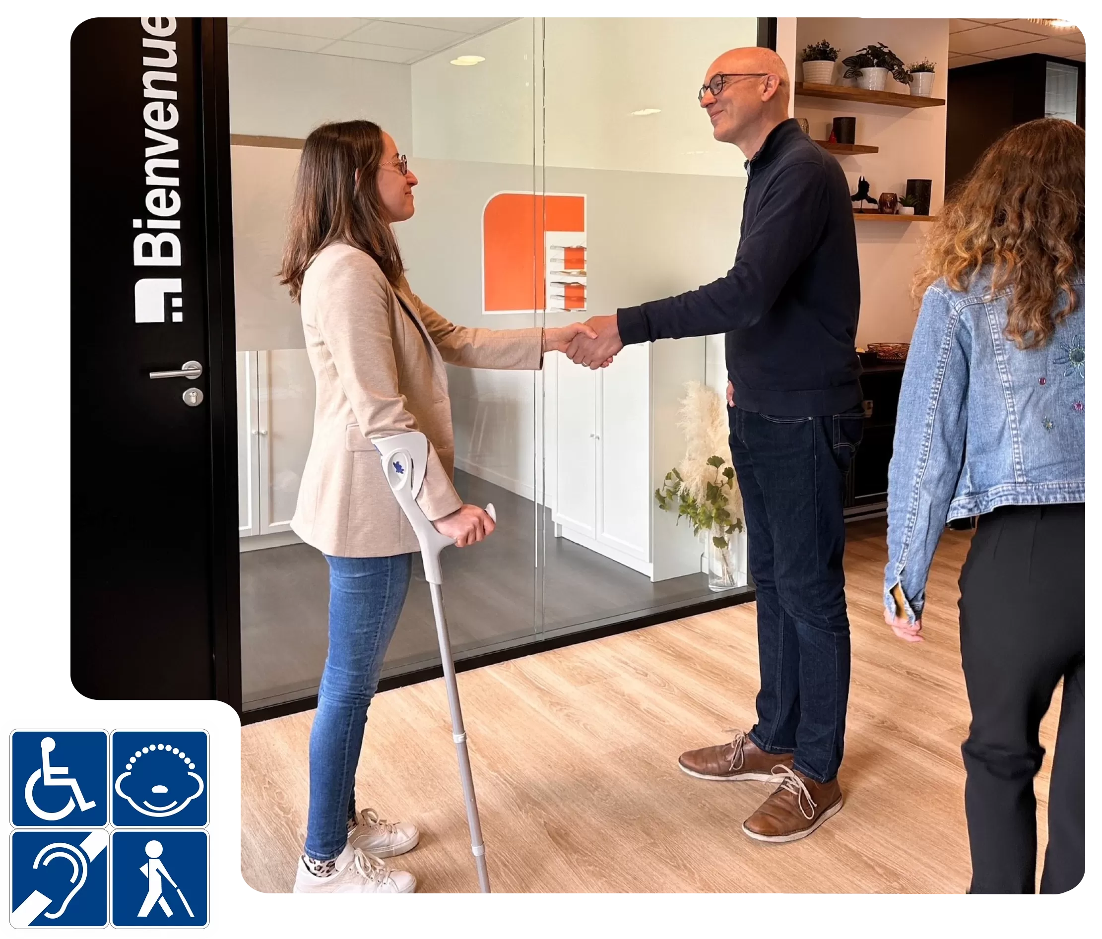 Un groupe échangeant dans un espace inclusif avec des pictogrammes d’accessibilité visibles.