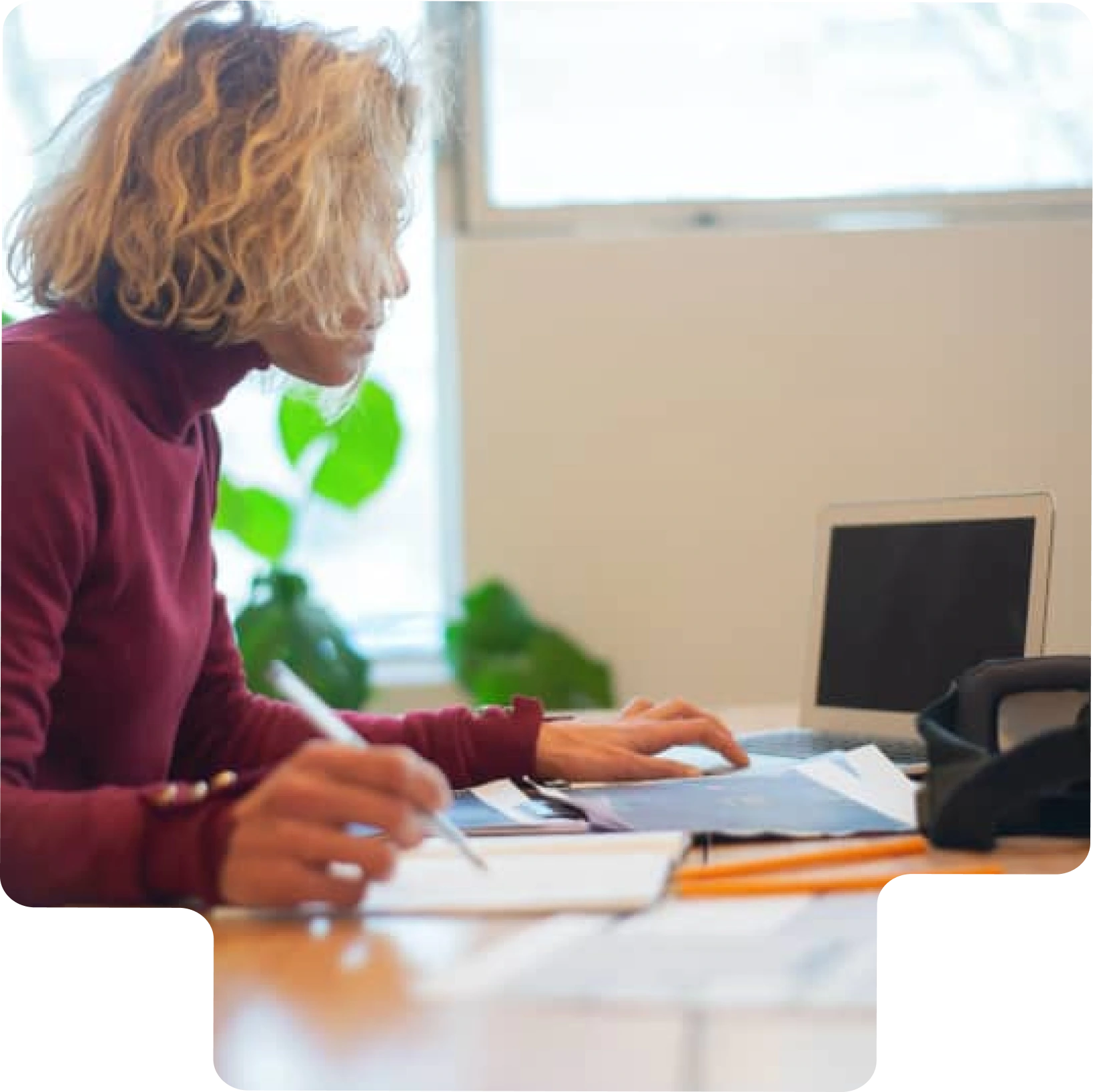Une femme concentrée sur son ordinateur en train de suivre une formation en ligne.
