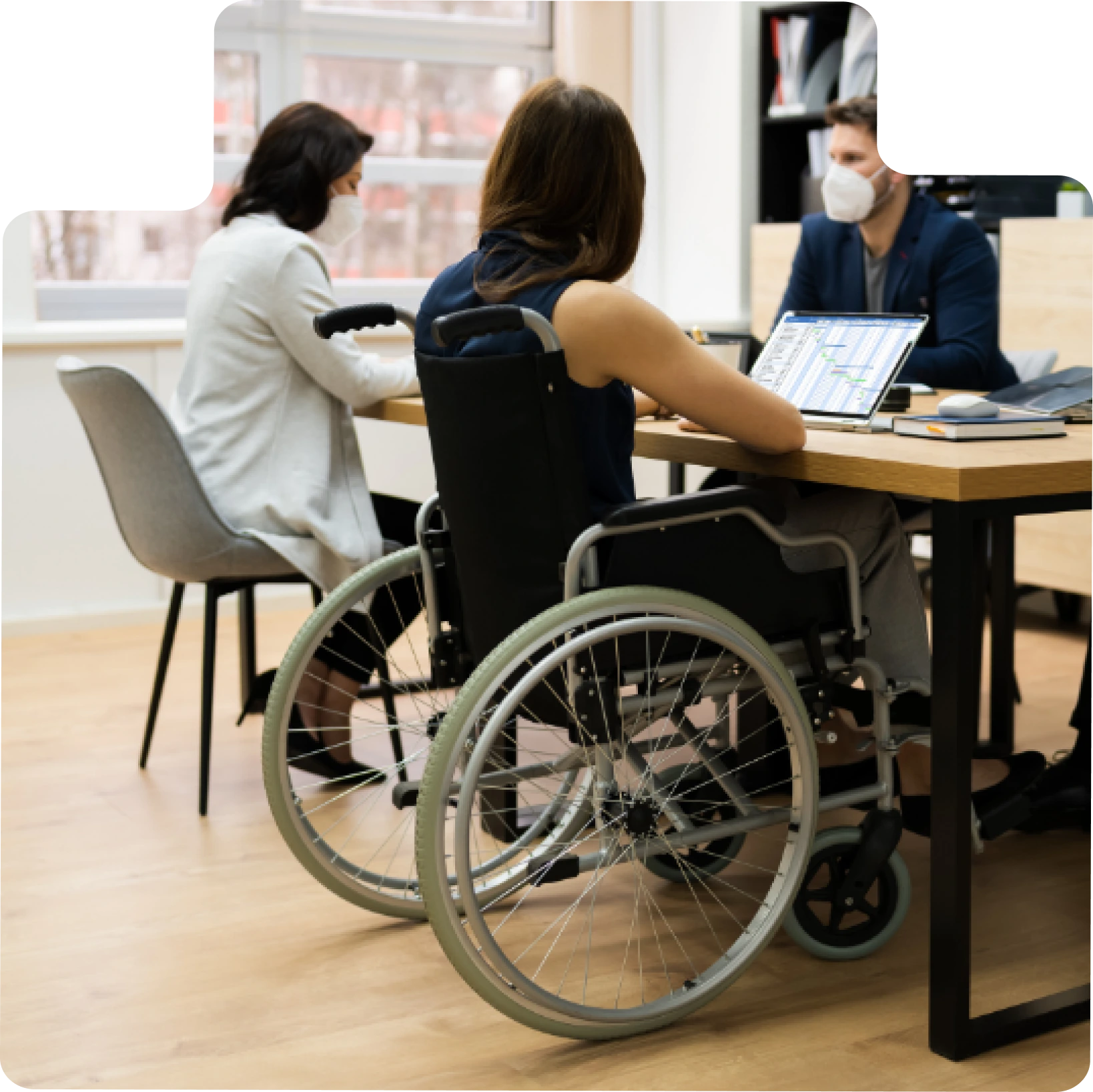 Une femme en fauteuil roulant participant à une réunion de travail avec des collègues.