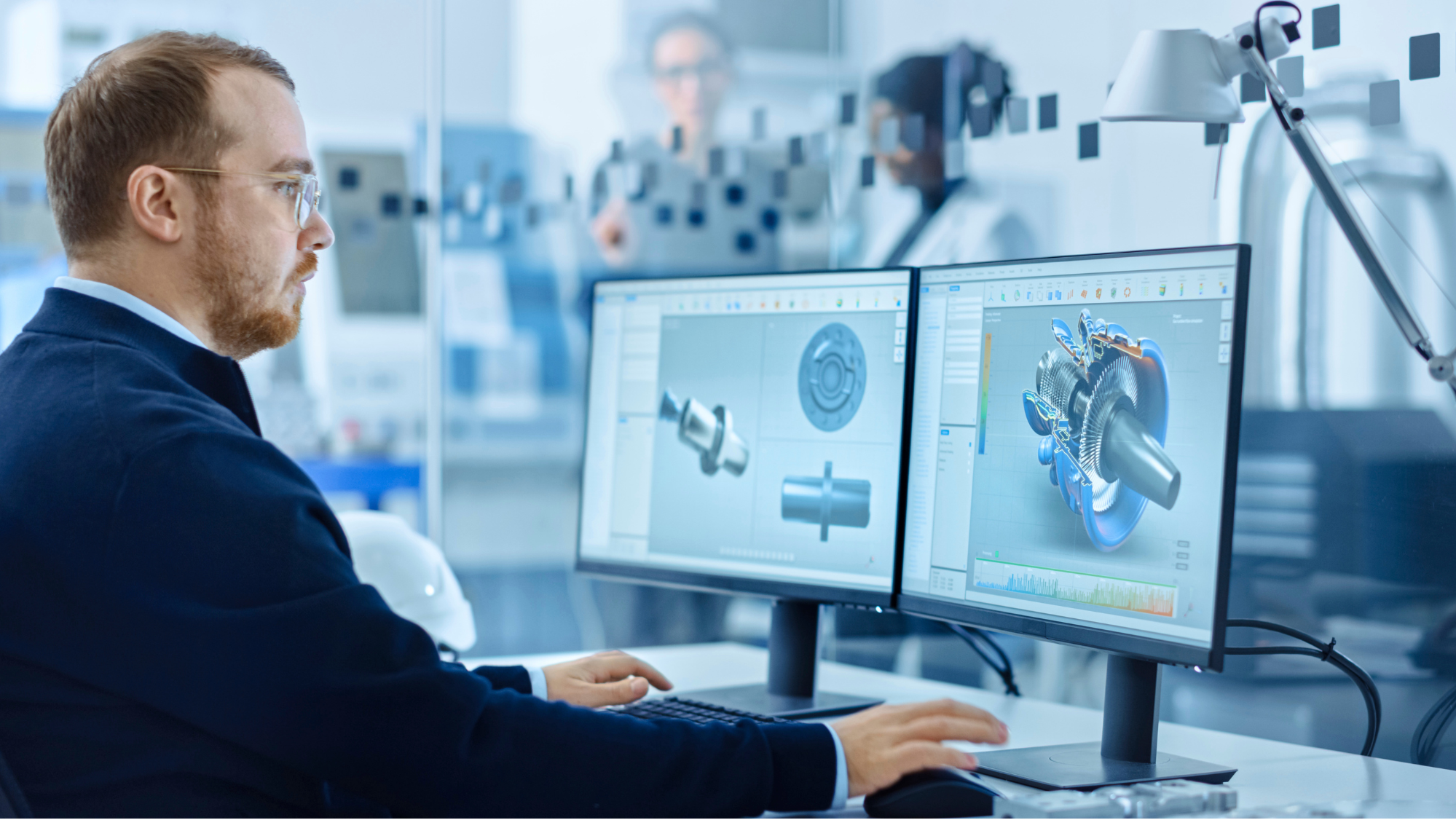 Homme utilisant un logiciel de conception 3D sur double écran dans un environnement professionnel