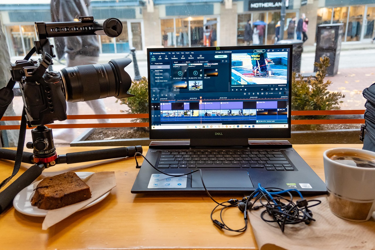Montage vidéo en cours sur ordinateur portable avec appareil photo professionnel et accessoires de tournage