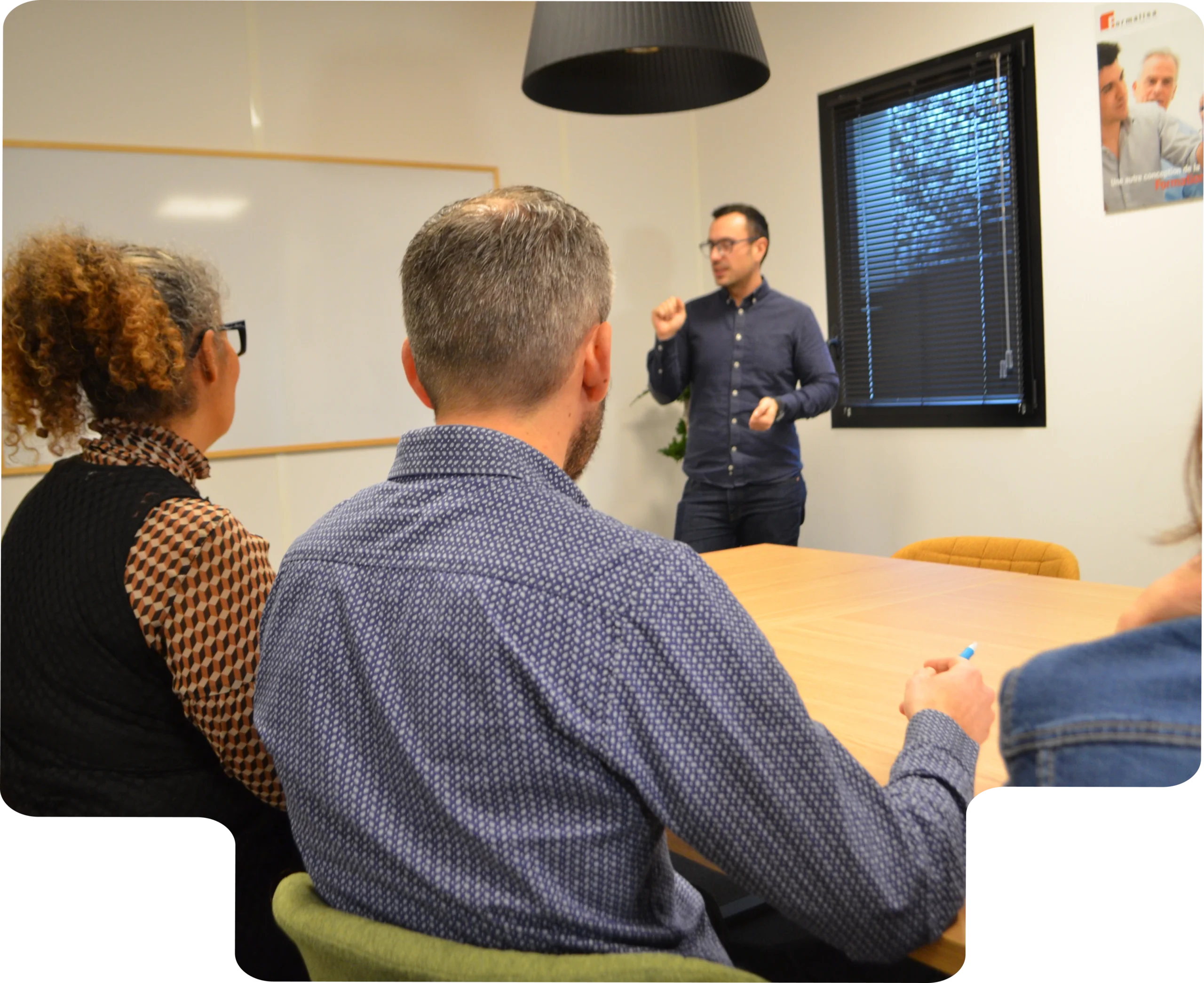 Une formation accessible à tous Formateur en salle animant une session de formation devant plusieurs participants, illustrant l’accompagnement inclusif
